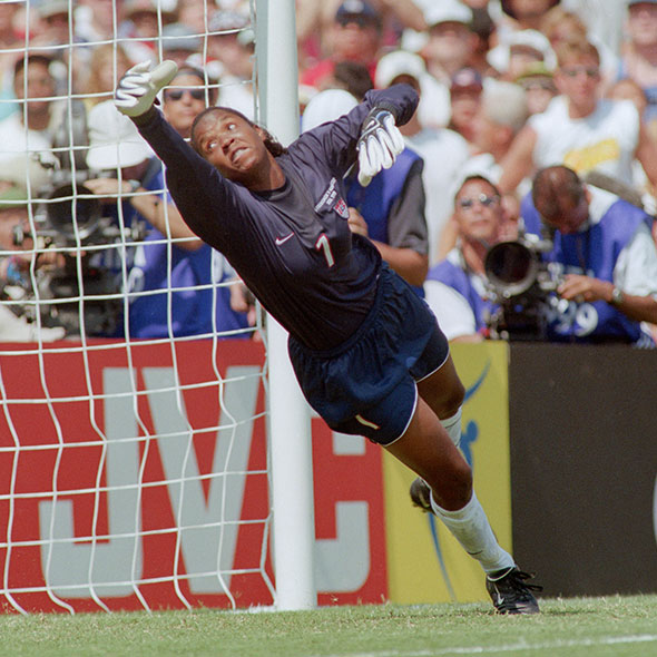 Briana Scurry diving for soccer ball on field
