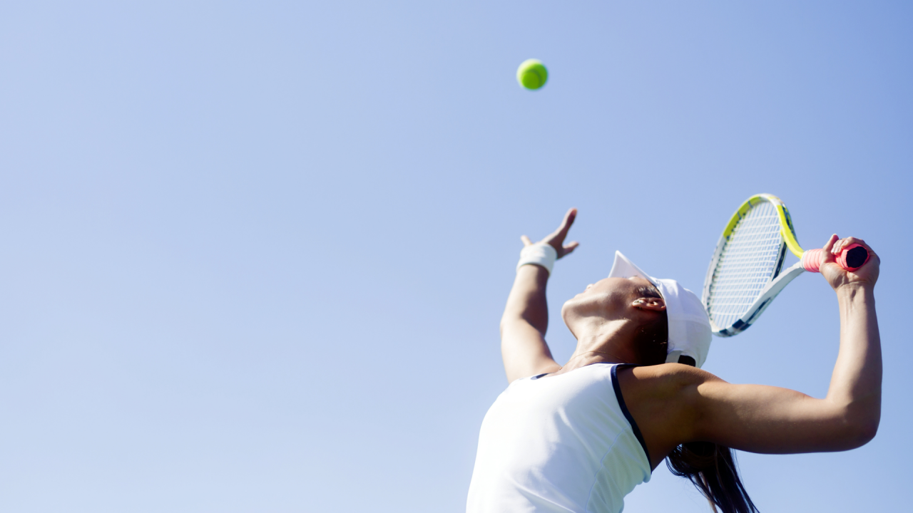 female tennis player about to hit tennis ball with racket