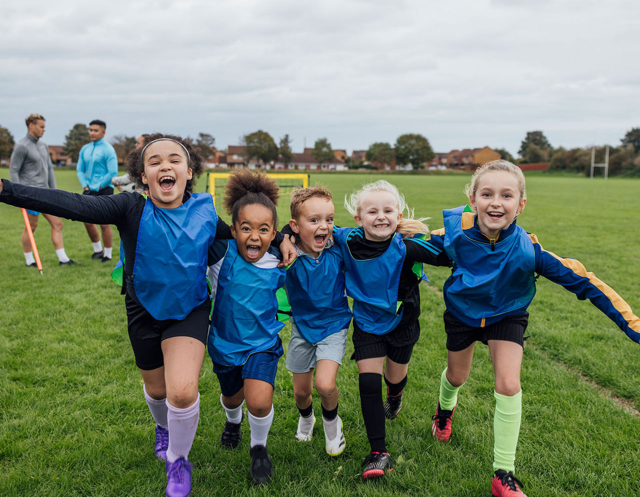 children huddled together on soccer field