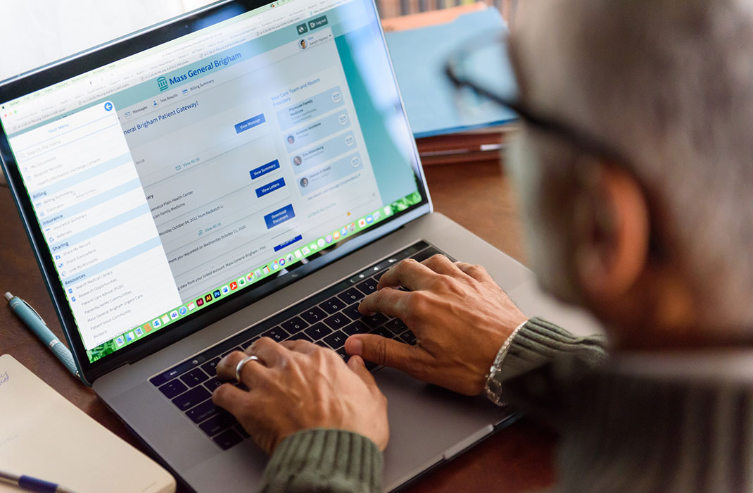 man working on a laptop with patient gateway on the screen