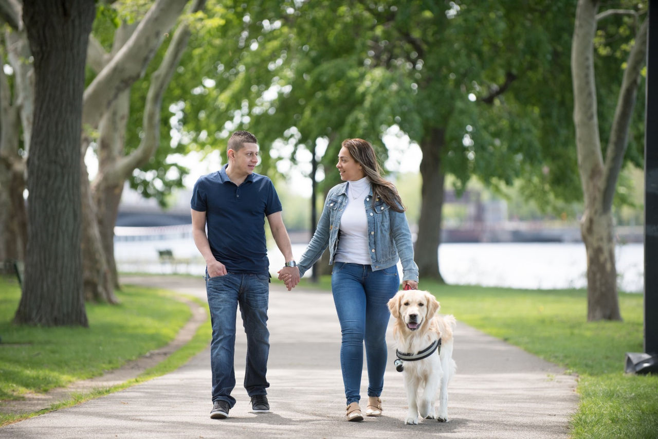 Man and woman walking on a path with a dog 