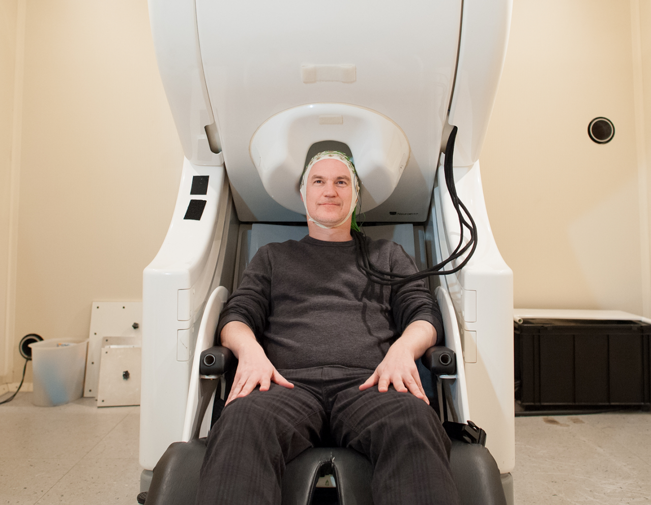 man sitting in imaging chair in exam room