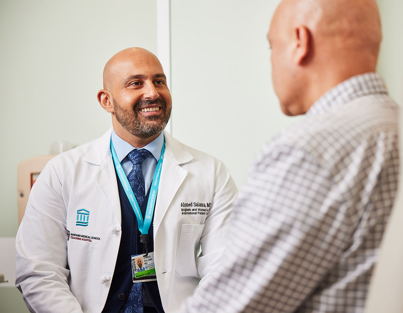 Dr. Ahmed Salama smiles at patient in exam room