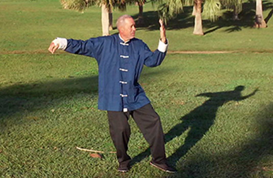 David practicando Tai Chi en un campo