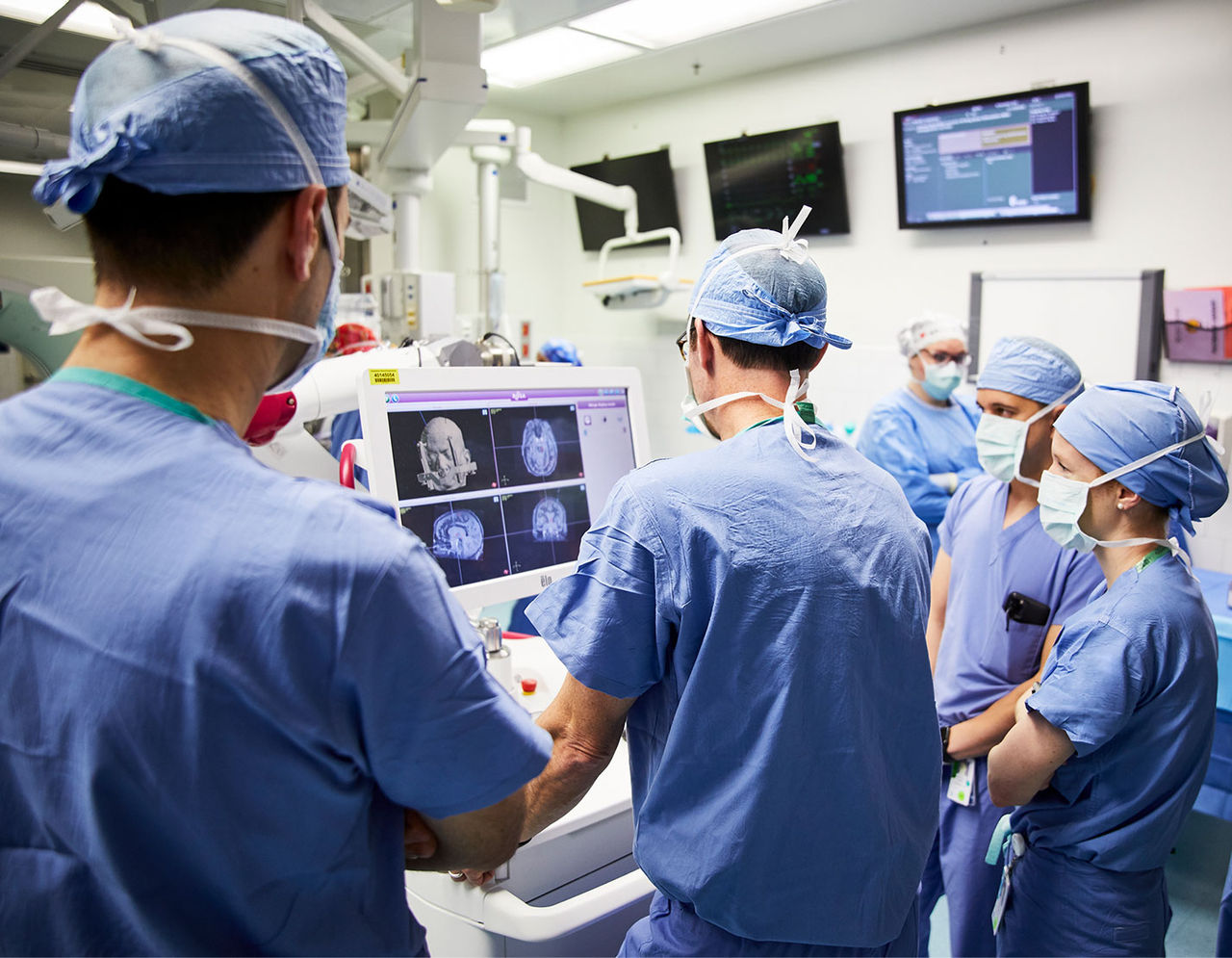 手术室里的医护人员在显示器前查看患者的扫描结果