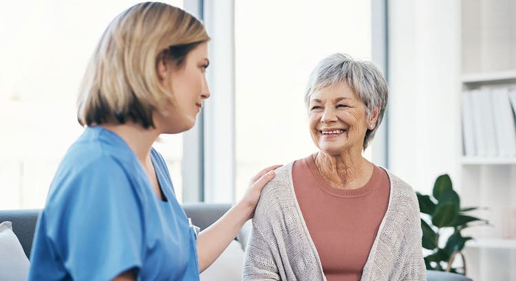 A healthcare provider speaks to an older female patient.